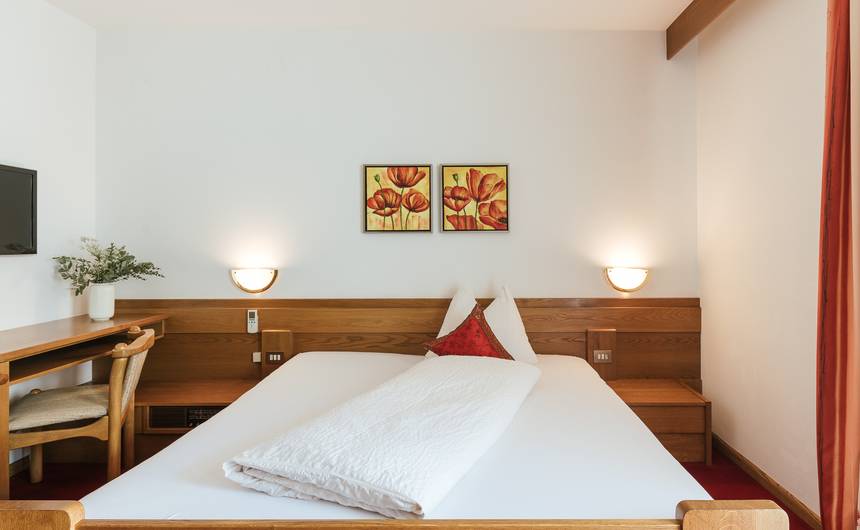 Modernes Hotelzimmer im Hotel Bauhof mit gemütlichem Doppelbett und Blick auf die Abendsonne Modernes Hotelzimmer im Hotel Bauhof mit gemütlichem Doppelbett und Blick auf die Abendsonne