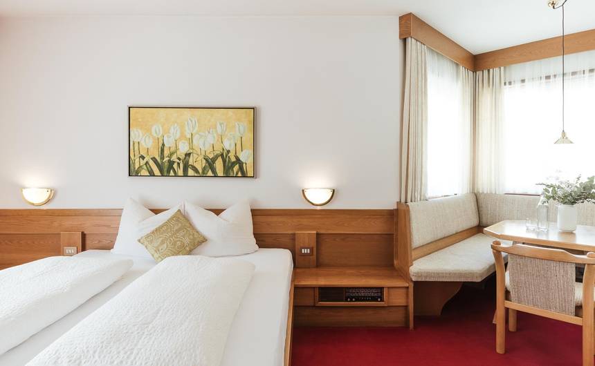 Modernes Hotelzimmer im Hotel Bauhof in Latsch mit Doppelbett, Holzmöbeln und Balkon Modernes Hotelzimmer im Hotel Bauhof in Latsch mit Doppelbett, Holzmöbeln und Balkon