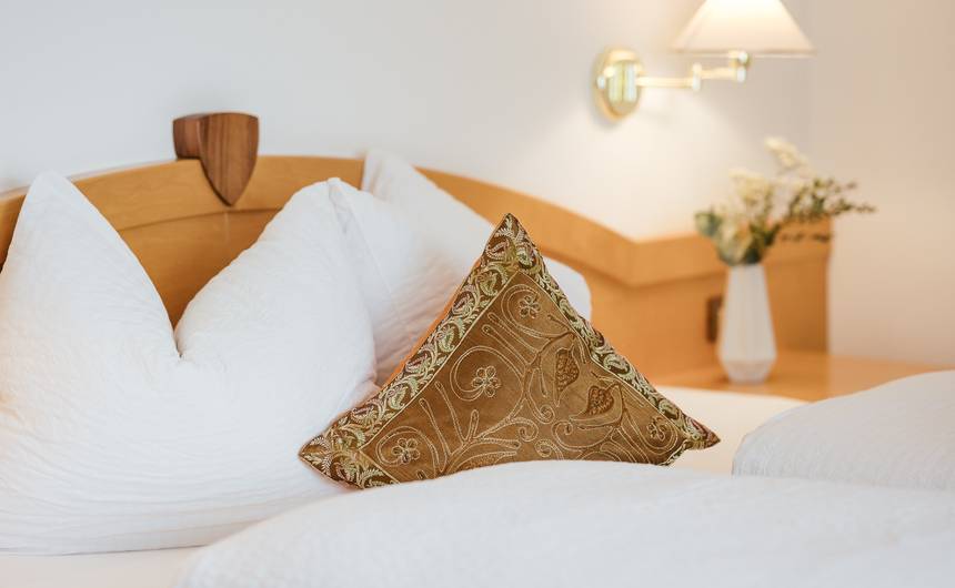 Modernes Hotelzimmer im Hotel Bauhof mit Doppelbett, Holzmöbeln und Balkon im Vinschgau Modernes Hotelzimmer im Hotel Bauhof mit Doppelbett, Holzmöbeln und Balkon im Vinschgau